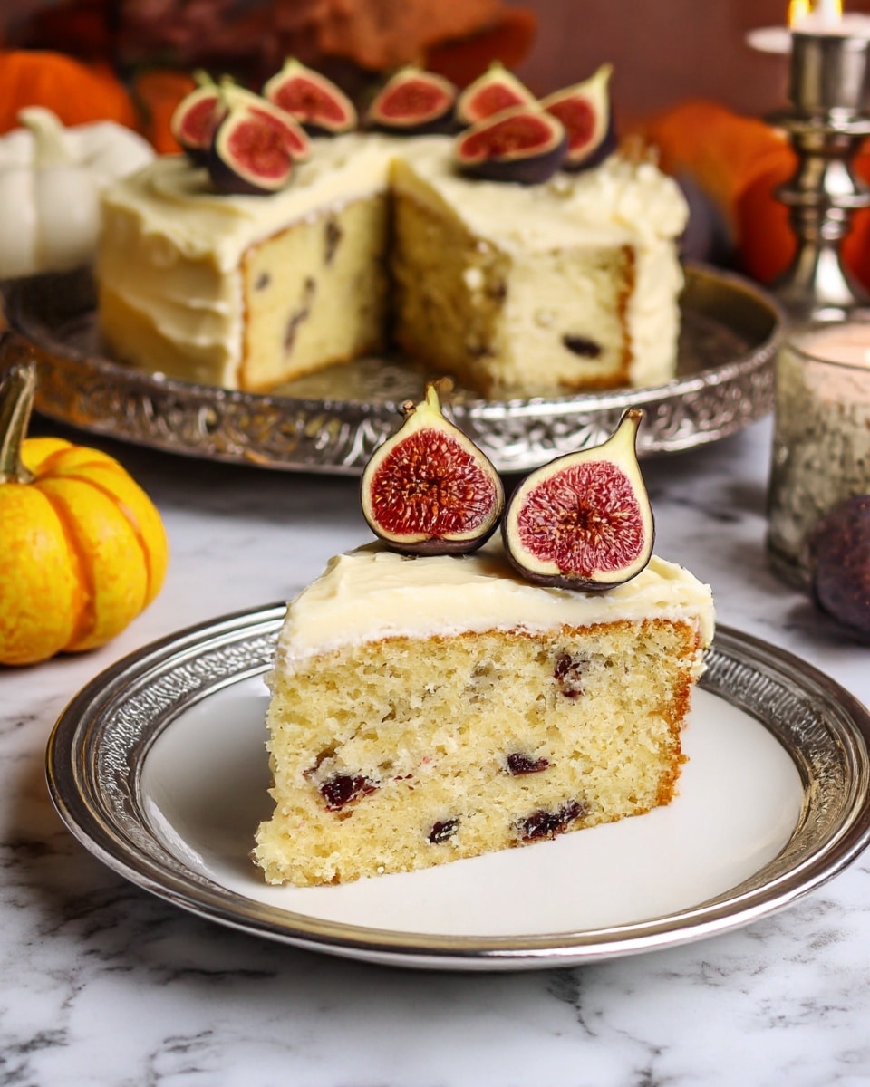 A slice of cake with two layers is shown on a white plate with a silver finish. The bottom layer is light yellow with visible pieces of dark fruit mixed inside, giving it a speckled texture. The top layer is thick and creamy, pale yellow in color, smoothly spread over the cake, with three halved figs placed on top, showing their reddish interior with small seeds. In the background, the rest of the cake with the same two layers sits on a decorative silver tray, with more fig halves arranged on its creamy top. The surface beneath is white marbled texture, and small yellow and white decorative pumpkins along with a silver candle holder add to the cozy setting. Photo taken with an iphone --ar 4:5 --v 7