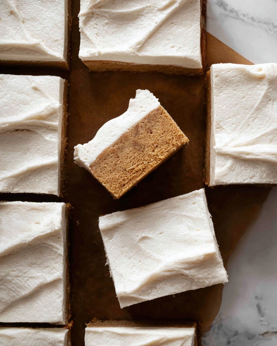 The image shows nine square pieces of a two-layered dessert arranged in a grid pattern on a brown baking tray. Each piece has a thick bottom layer that looks dense and brown, topped with a thick layer of light beige creamy frosting, which is spread smoothly with slight spatula marks. Two of the squares are slightly turned and stacked in the center, showing the contrast between the soft frosting and the firm base. The dessert pieces have clean, sharp edges, and the brown base has a slightly crumbly texture. The background is a white marbled texture. photo taken with an iphone --ar 4:5 --v 7