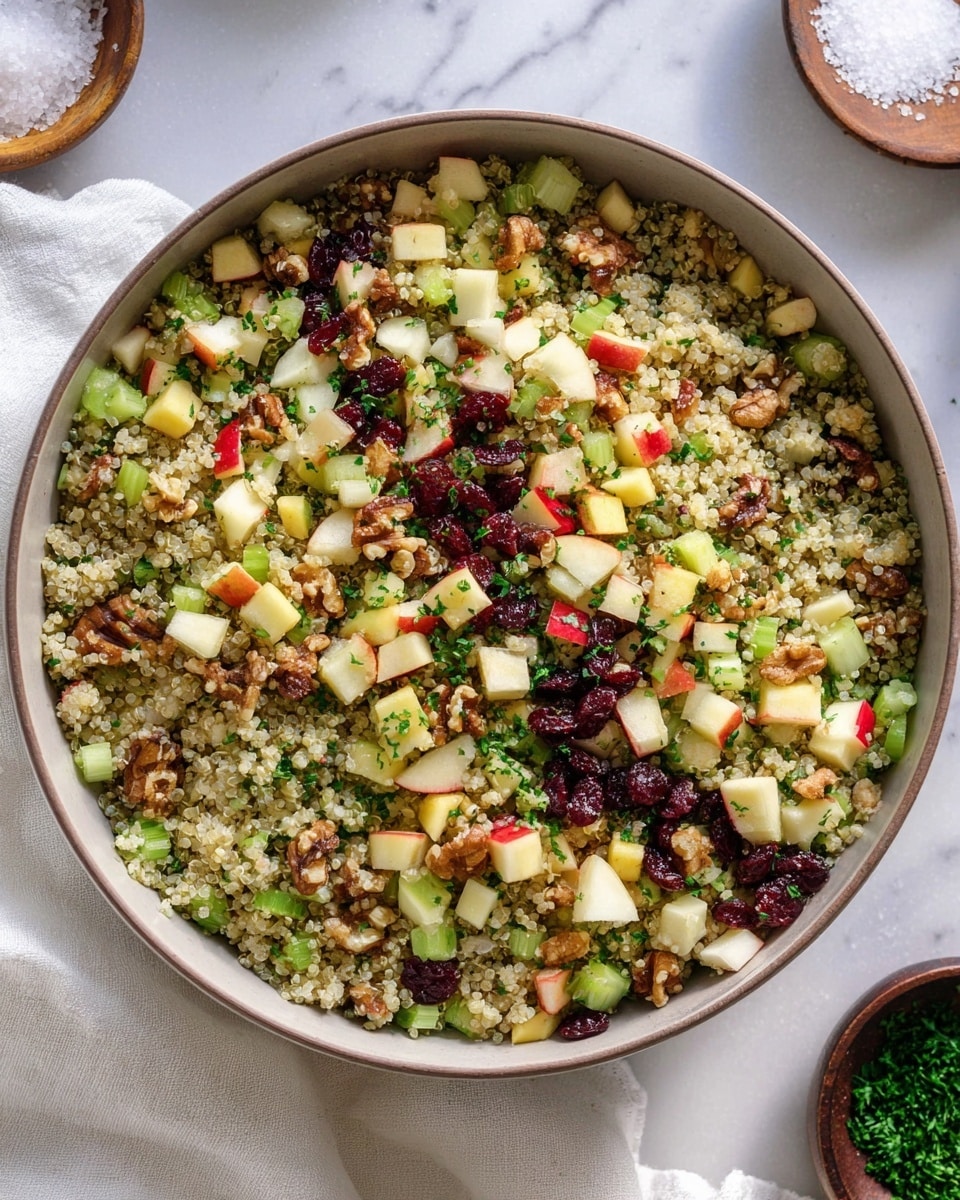 A close-up of a bowl filled with a three-layer salad, where the base layer is fluffy quinoa made of different colors like white, red, and black quinoa. The second layer has finely chopped green celery pieces scattered all over. The top layer shows small red apple cubes with skin on, mixed with walnut pieces and dark dried cranberries, all combined with chopped green parsley. A golden spoon with a white and gold handle is partially inside the bowl. The bowl is white and sits on a surface with a white marbled texture. photo taken with an iphone --ar 4:5 --v 7