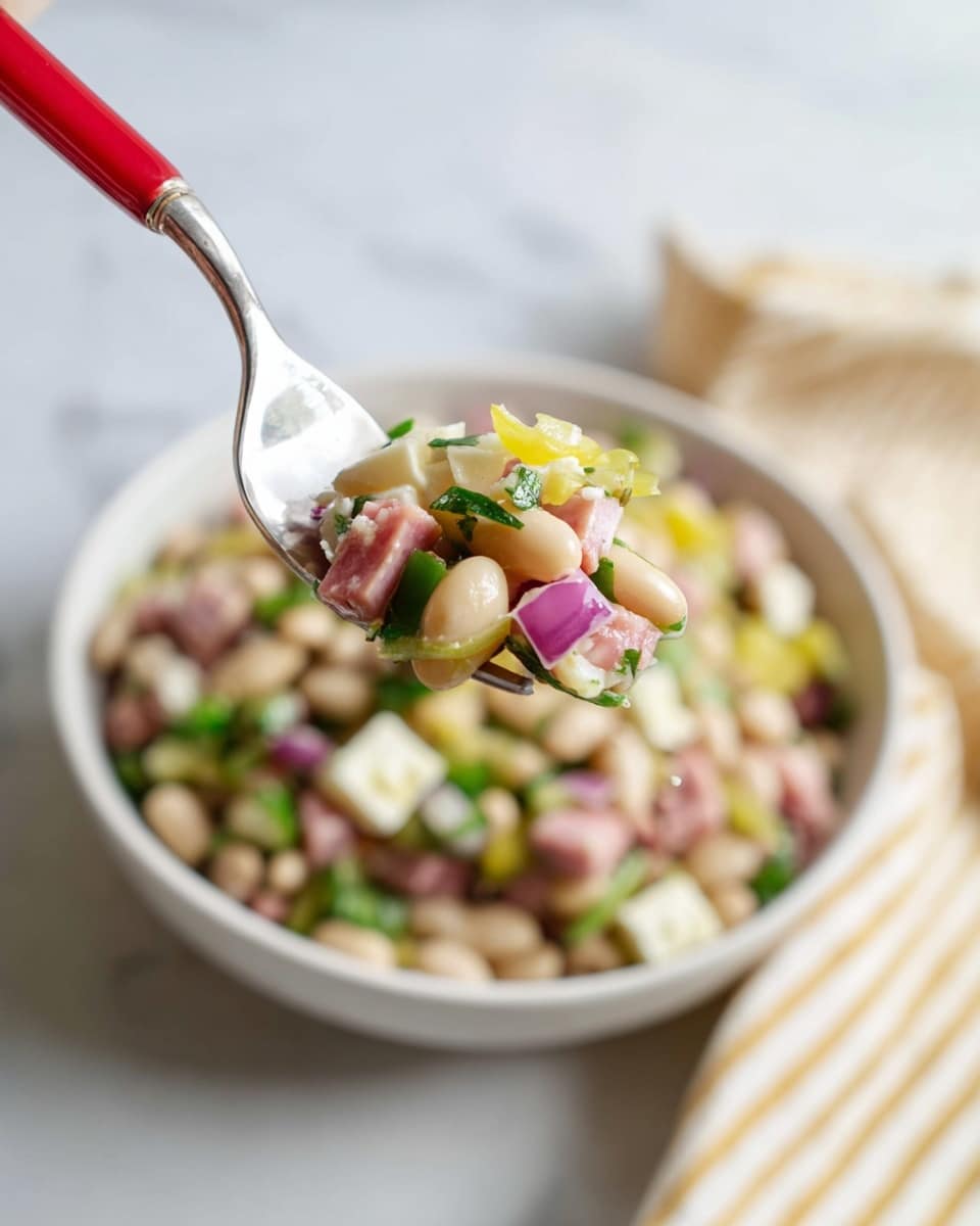 A close-up of a silver fork with a bright red handle holding a small bite of a mixed bean salad above a white bowl filled with the same bean salad. The salad has layers of small white beans, diced light pink ham, chunks of white cheese, bright green parsley leaves, small pieces of red onion, and rings of yellow pepper. The background shows a white marbled surface with a beige and white striped cloth to the right side. photo taken with an iphone --ar 4:5 --v 7