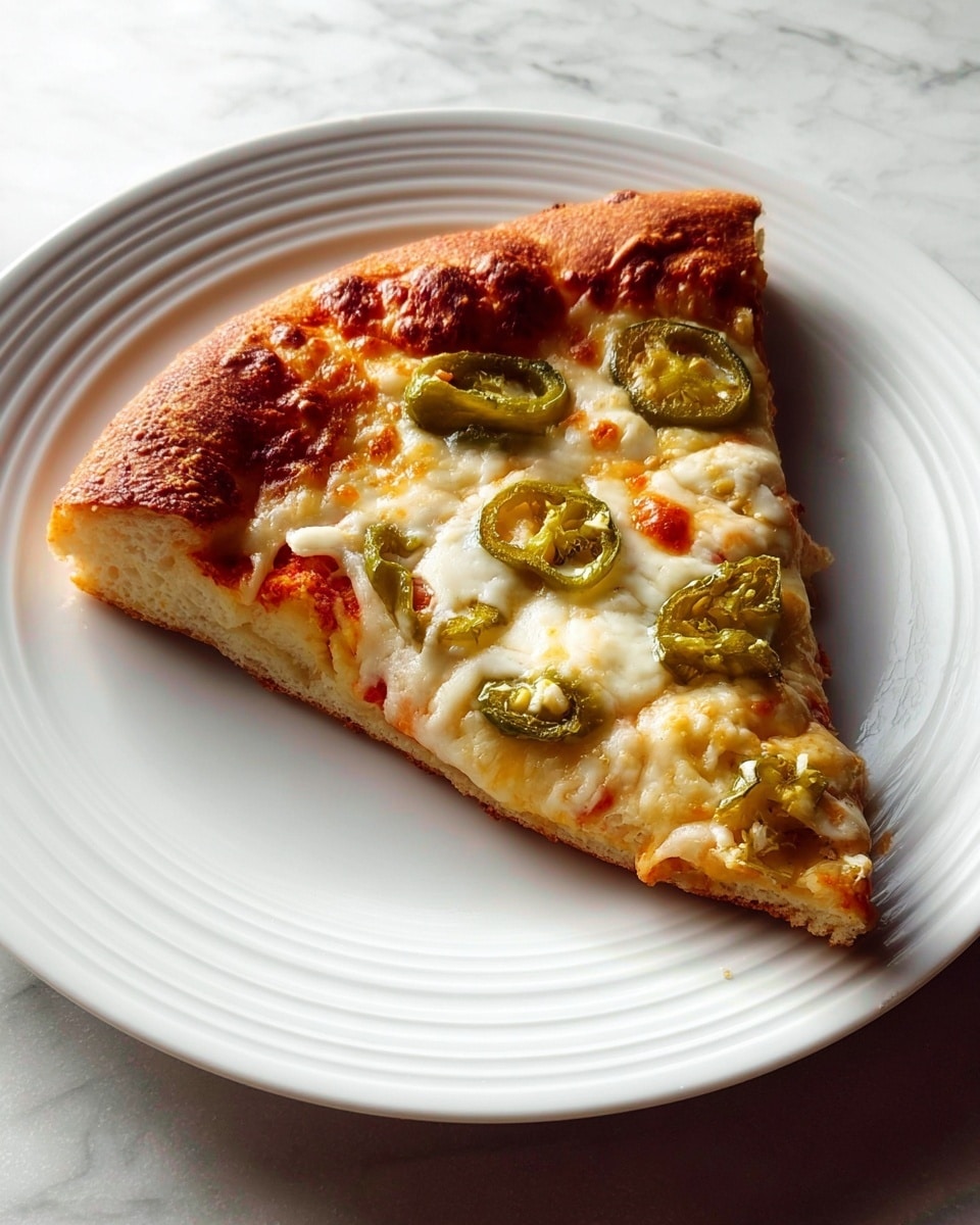 A single slice of pizza resting on a white plate with circular ridges, placed on a white marbled surface. The pizza has a thick, golden brown crust with a slightly puffed edge that looks crispy and well-baked. The base layer is a light, airy dough with a pale color. Above this is a layer of melted white cheese that is soft and creamy with some browned spots from baking. Scattered on top are slices of green jalapeño peppers, adding a hint of green and texture contrast to the cheese layer. The lighting highlights the textures of the crust and toppings beautifully, giving the slice an appetizing look. Photo taken with an iphone --ar 4:5 --v 7